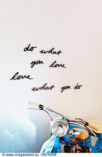House interior wall with hand written positive motto design and motorcycle
