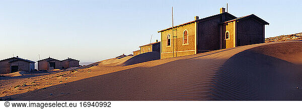 Houses buried in sand in deserted village.