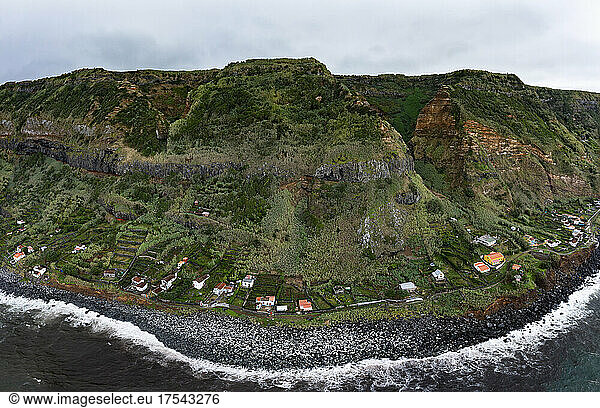 Houses on coast with mountain range at Rocha da Relva  Sao Miguel Island  Azores  Portugal
