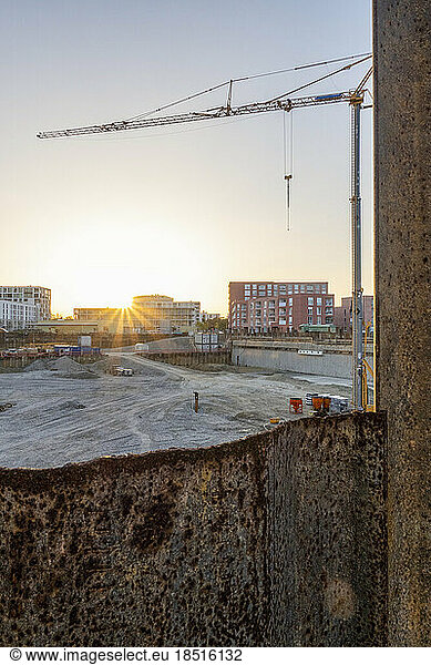 Housing construction site with crane at sunset