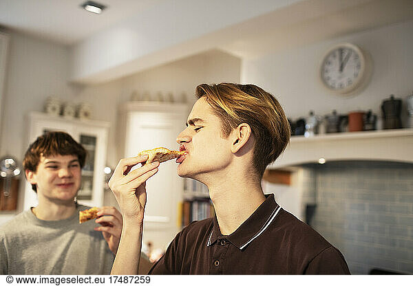 Hungrige Teenager essen Pizza in der Küche