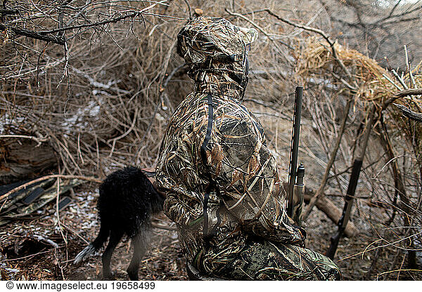 Hunter and dog in duck blind await waterfowl on Upper Mississipp