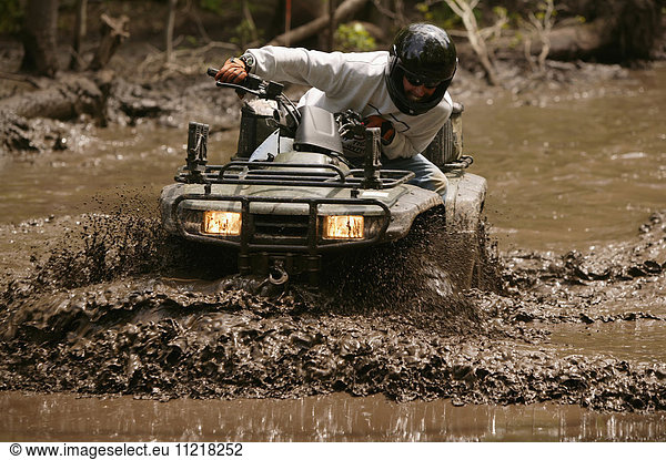 Hunter Driving All Terrain Vehicle In Mud