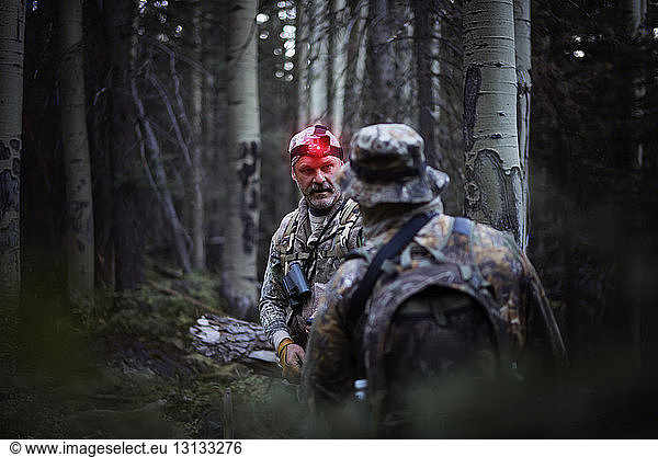Hunters talking while hunting in forest