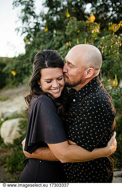 Husband Hugging & Kissing Wife in Garden in San Diego