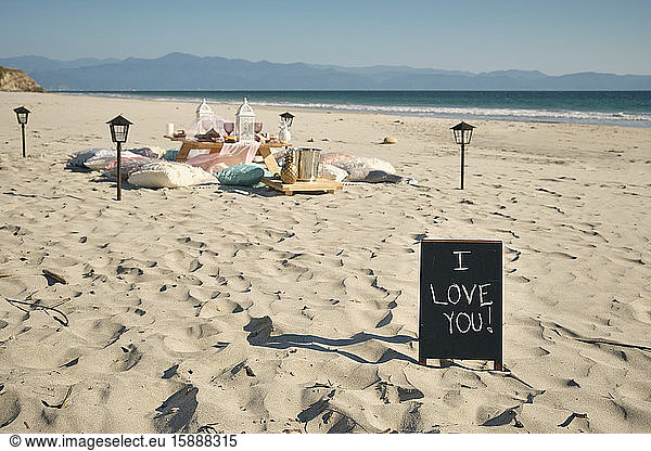 I LOVE YOU sign on placard near dining table at beach against clear blue sky during sunny day  Nayarit  Mexico