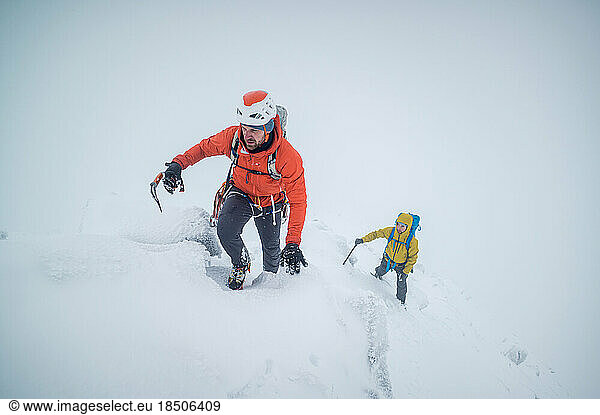 Ice climbers climbing a frozen alpine ridge on a mountain