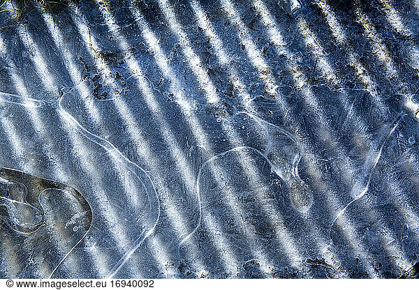 Ice  contours of frozen water  shadows and sunlight.