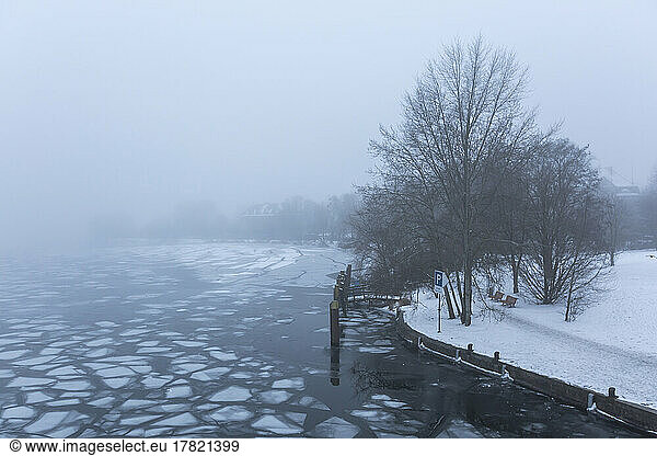 Ice floating in river Havel on foggy winter day