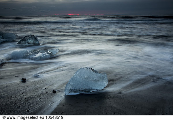 Ice on stormy cold ocean beach  Iceland