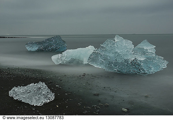 Icebergs at shore against sky
