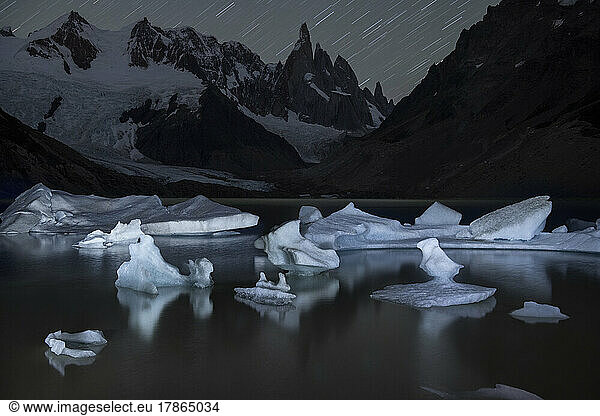 Icebergs dot the shore of Laguna Torre  illuminated at night in