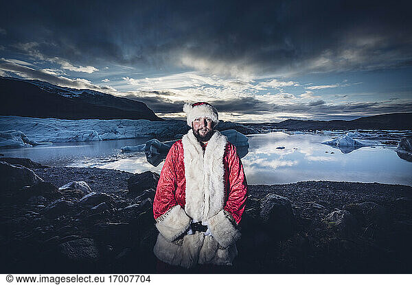 Iceland  portrait of Santa Claus standing in front of glacier