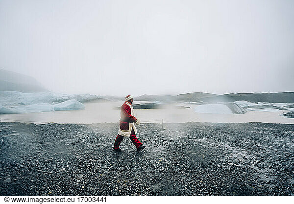Iceland  Santa Claus walking in glacier landscape