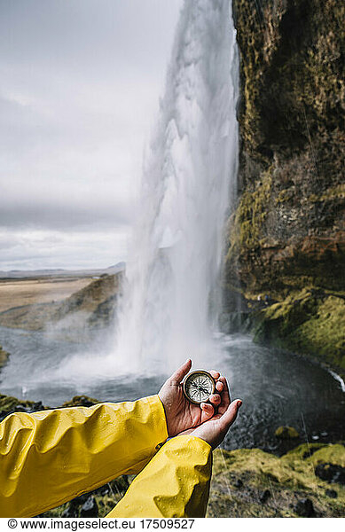 Iceland  Seljalandsfoss Waterfall  woman's hand holding compass