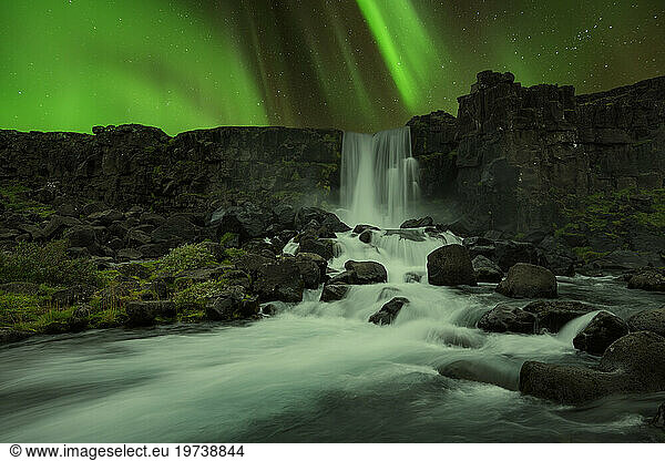 Iceland  Sudurland  Aurora Borealis over Oxararfoss waterfall at night