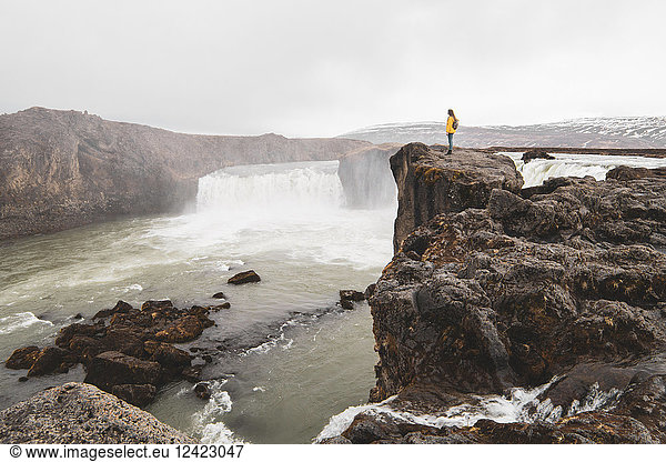 Iceland woman standing at Godafoss waterfall