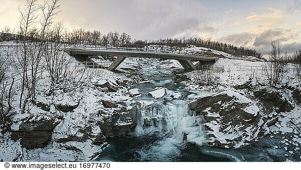 icy waterfall and bridge in panoramic from aerial view