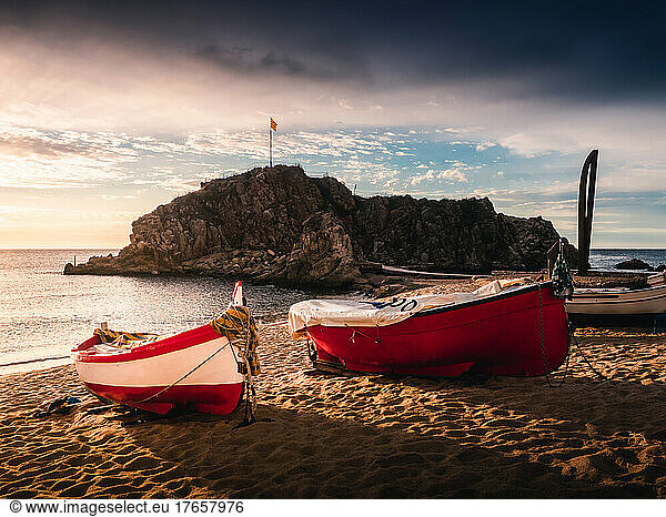 Idyllic sunrise in the beach with fishers boats