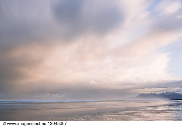 Idyllic view of Rockaway Beach against cloudy sky