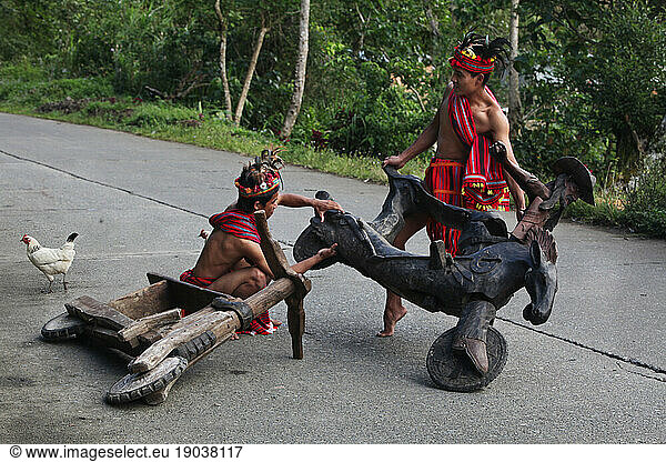 Ifugao tribesmen repairing wooden scooter.