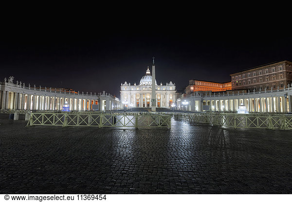 Illuminated cathedral and column at St Peter Square  Rome  Italy