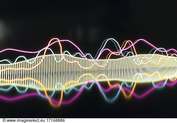Illuminated colorful frequency pattern against black background