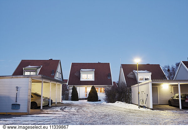 Illuminated houses against clear sky during winter
