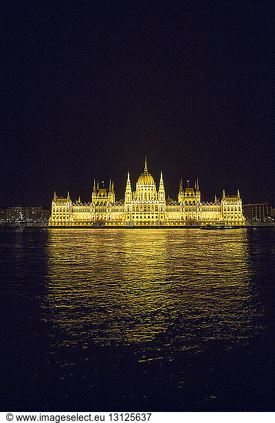 Illuminated Hungarian Parliament Building in front of Danube River at night