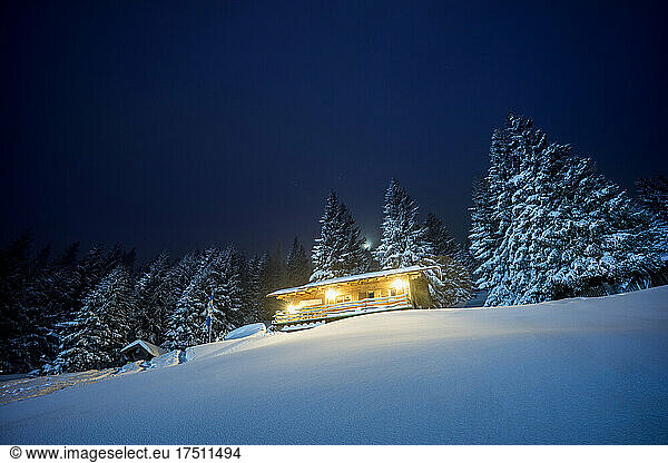 Illuminated mountain hut at night