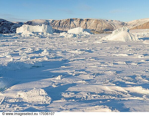 Im Winter in das Meereis des Uummannaq-Fjordsystems eingefrorene Eisberge im Nordwesten Grönlands  weit jenseits des Polarkreises. Nordamerika  Grönland  dänisches Gebiet.