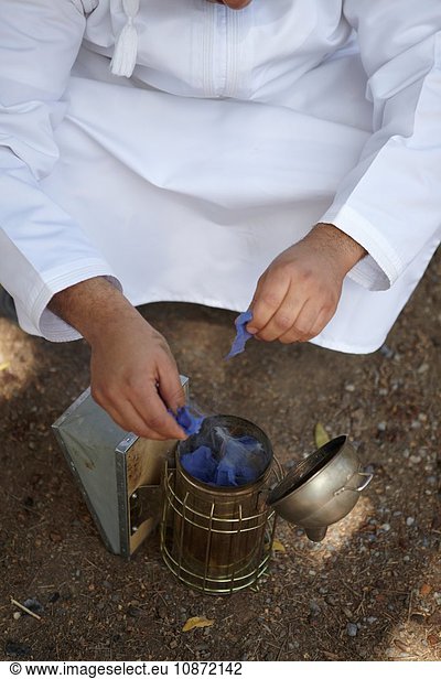 Imker zündet Bienenstockraucher an  Savq  Jabal Akhdar  Oman  Naher Osten