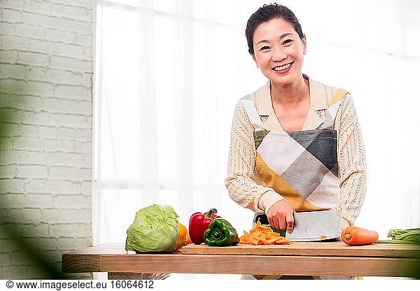 In der Küche hacken die Frauen mittleren Alters Gemüse