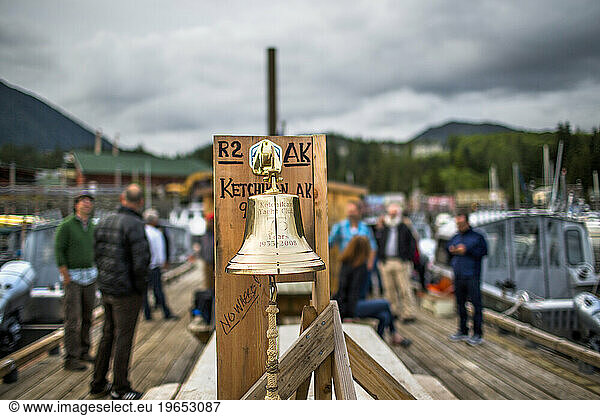 In Ketchikan  Alaska  a bell sits on a dock ready to be rung after teams arrive on a cloudy day. The 750 mile Race to Alaska is an adventure where teams race from Port Townsend  WA