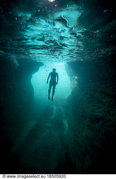 in the sea  a man floats in apnea just under the surface of the water