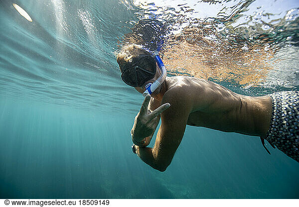 in the sea  a man in a bathing suit is snorkeling