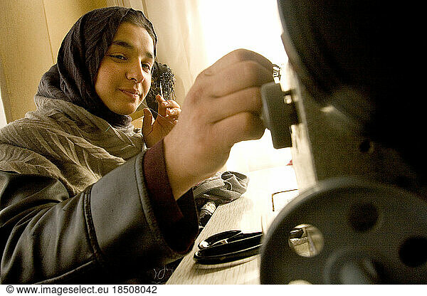 In the workroom of an Afghan designer  a young woman works on an electric sewing machine in Kabul  Afghanistan.