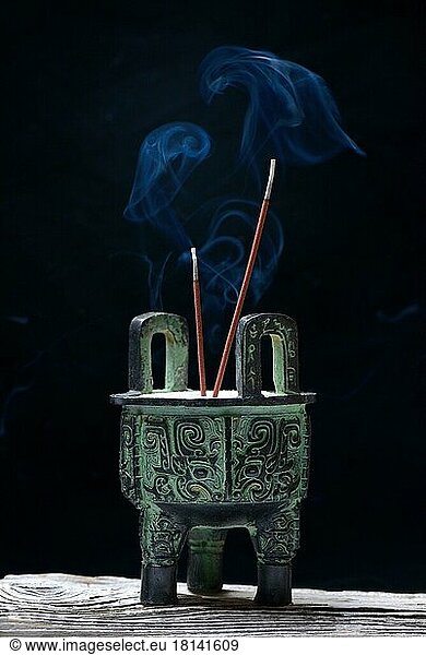 Incense burner with burning incense sticks