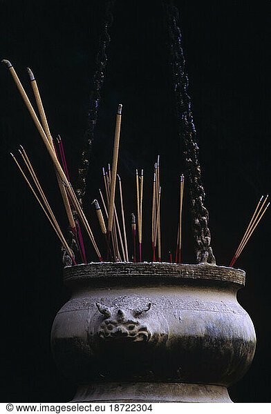 Incense burning in hanging pot at temple in Singapore.