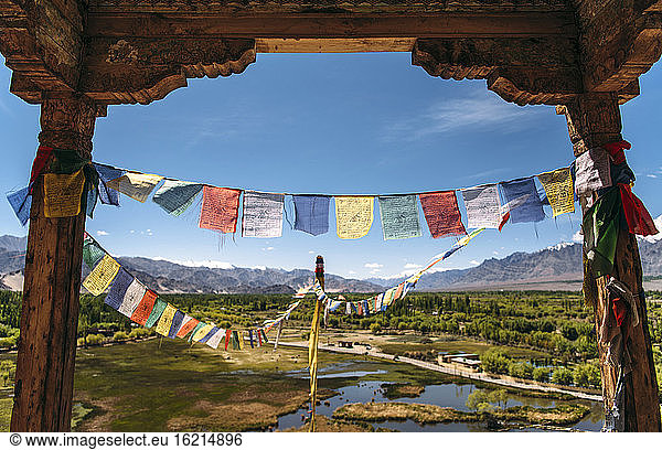 India  Ladakh  Colorful prayer flags hanging between two old columns
