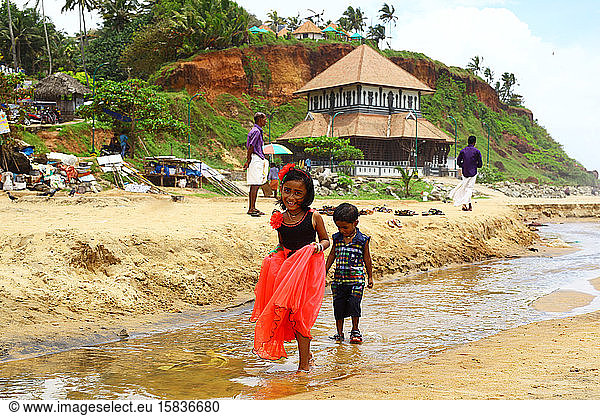 Indian children walking on the river on the waterfront.