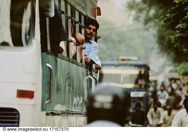 INDIEN Neu-Delhi -- Juni 2004 -- Ein Fahrgast lehnt sich aus dem Fenster eines Busses im Zentrum Neu-Delhis. Überfüllte Straßen sind in dieser Metropole die Regel  und die neue U-Bahn wird dazu beitragen  dass Busse und Straßen weniger überfüllt sind. Immer mehr Inder sind jedoch wirtschaftlich in der Lage  mehr Autos und Motorräder zu kaufen als je zuvor. Im Vergleich zu den meisten anderen Ländern ist Indien ziemlich fortschrittlich  was den Einsatz von Technologie angeht - wie dieser Bus  der mit komprimiertem Erdgas (CNG) betrieben wird -- Bild von Jon Mitchell / Lightroom Photos.