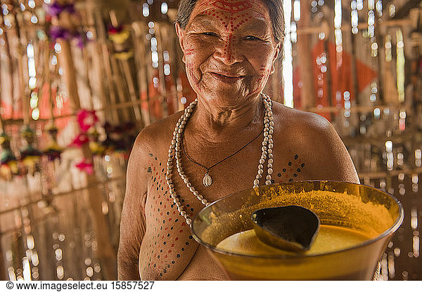 Indigene Frau im Dorf Dessana zeigt typische Lebensmittelvase
