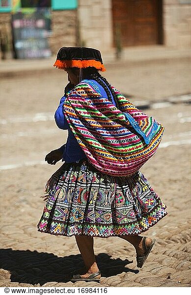 Indigene Frau in traditioneller Kleidung trägt eine Satteltasche im Stadtzentrum von Pisac  Region Cusco  Urubamba-Tal  Peru  Südamerika.