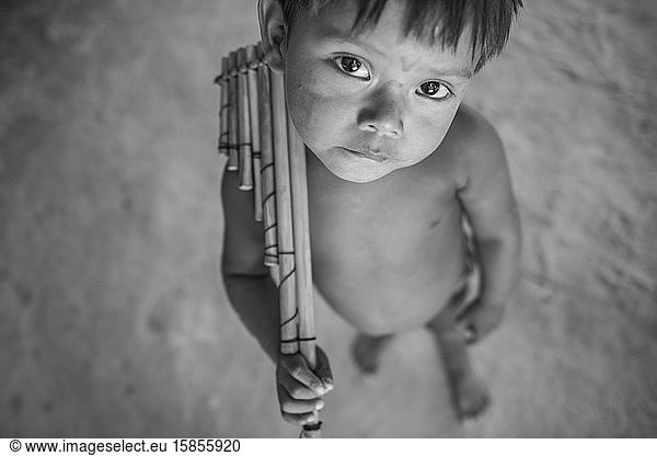 Indigenes Kind hält seine typische Flöte im Dorf Dessana