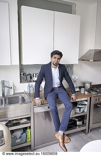 Indischer Geschäftsmann in seiner Küche