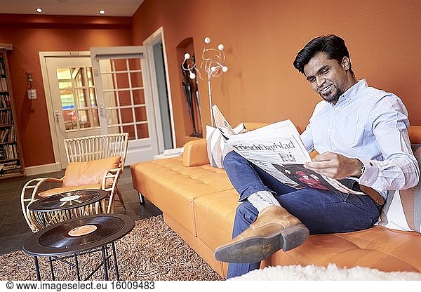 Indischer Geschäftsmann liest Zeitung in der Lobby