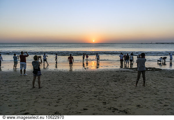 Indonesia  Bali  Denpasar  Tourists at Kuta beach photographing sunset
