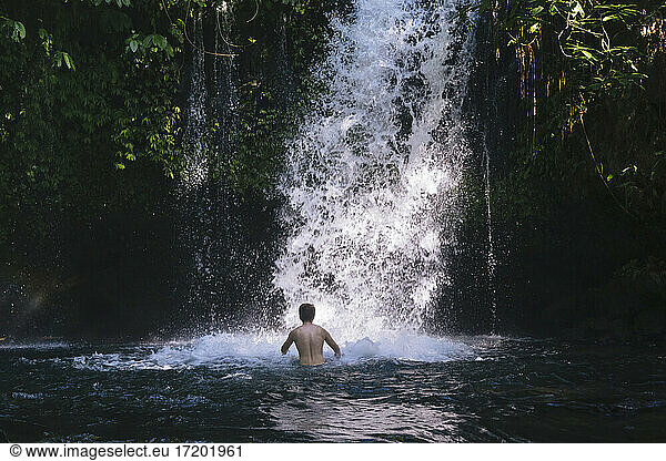 Indonesia  Bali  Man bathing in waterfall