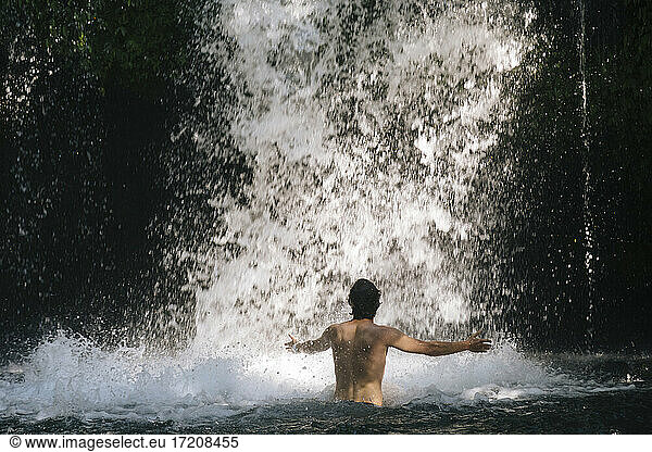 Indonesia  Bali  Man bathing in waterfall